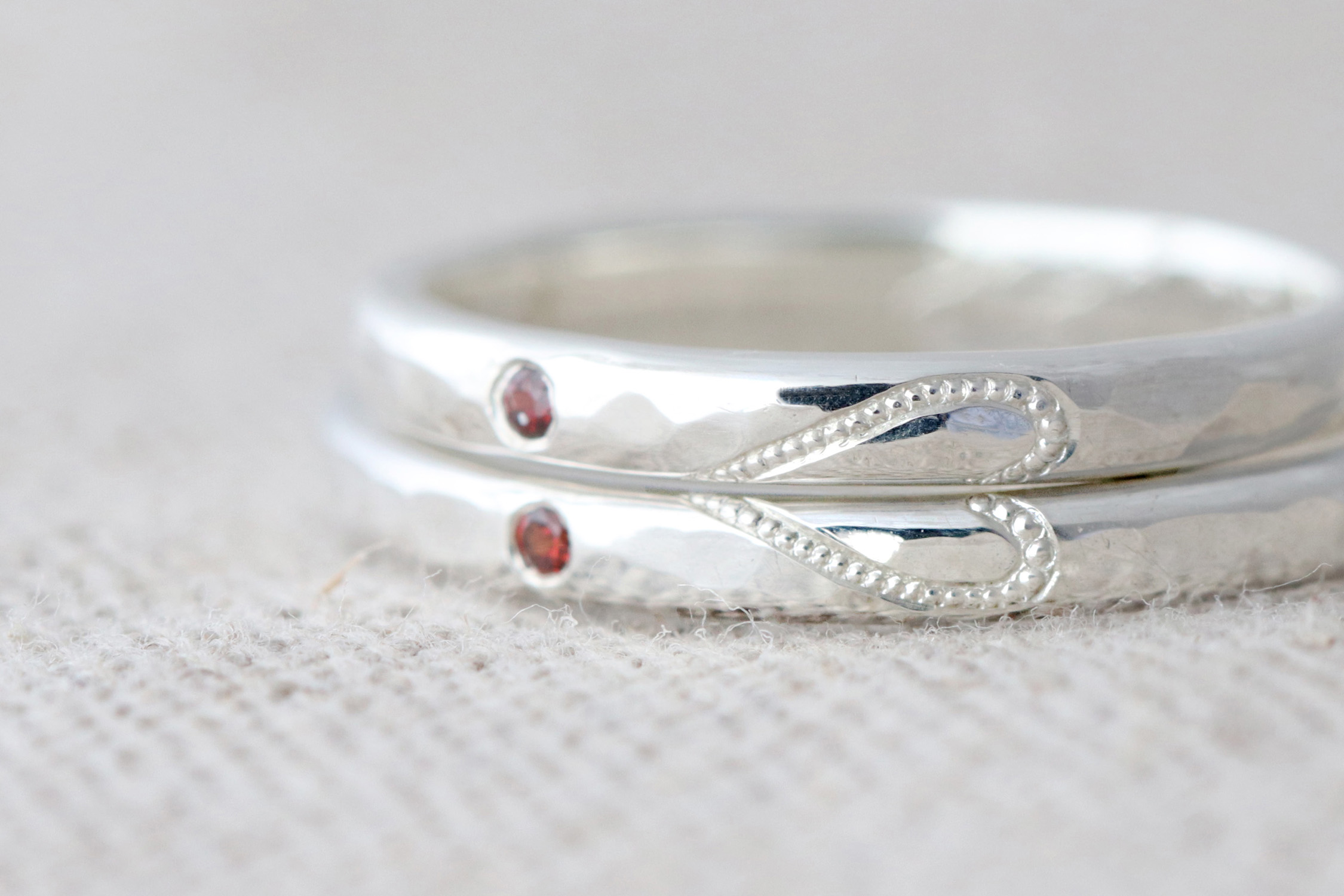 ミルグレインのハートに寄り添うガーネットがおしゃれなペアリング